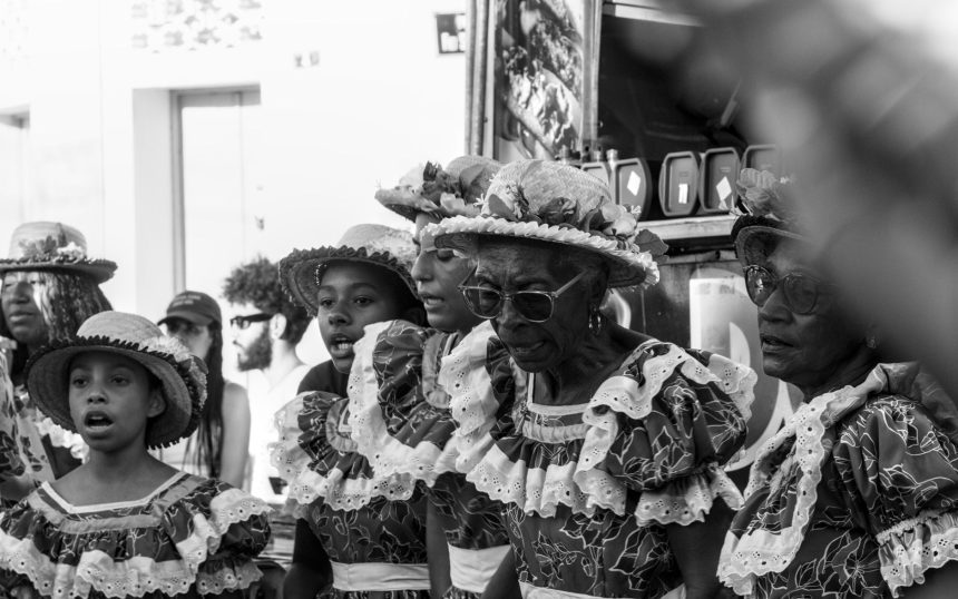 Pessoas vestidas com trajes tradicionais participam de uma manifestação cultural em São Cristóvão, Sergipe.
